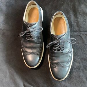 Men’s black leather Cole Haan wingtip shoe.